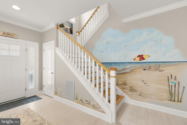 foyer with hardwood / wood-style floors and crown molding