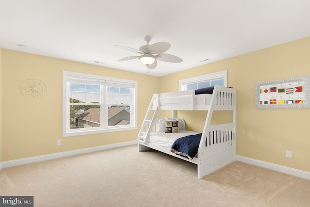 carpeted bedroom featuring ceiling fan and multiple windows