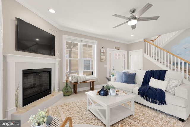 living room featuring crown molding, a fireplace, and ceiling fan