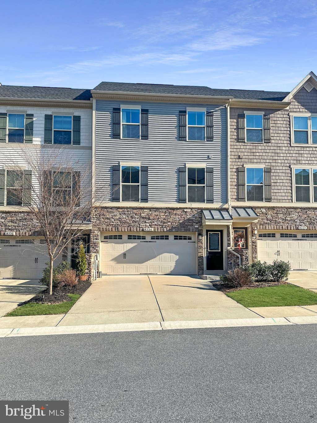 multi unit property with a garage and concrete driveway