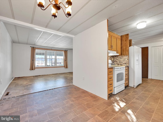 kitchen featuring an inviting chandelier, white appliances, and tasteful backsplash