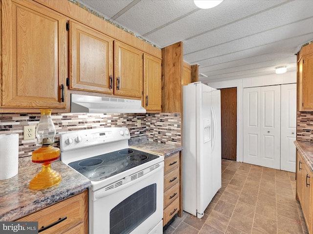 kitchen featuring light stone counters, white appliances, and decorative backsplash