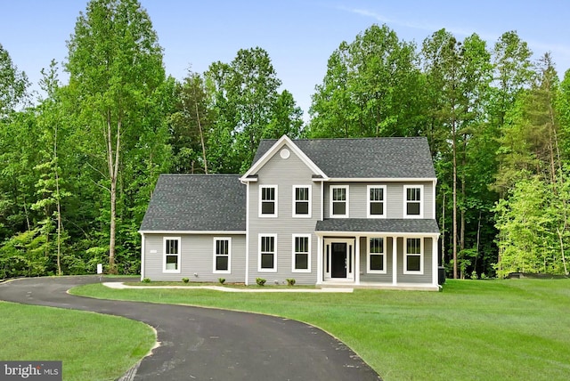 colonial home with a shingled roof and a front yard