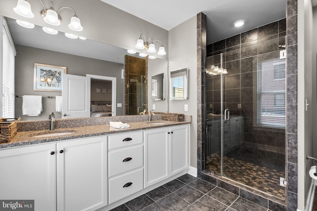 bathroom featuring a sink, a wealth of natural light, a stall shower, and double vanity