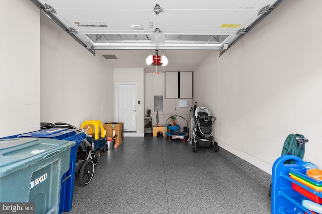 garage with electric panel, a garage door opener, and baseboards