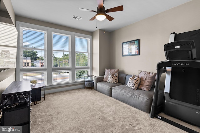 living room with visible vents, a ceiling fan, and carpet flooring