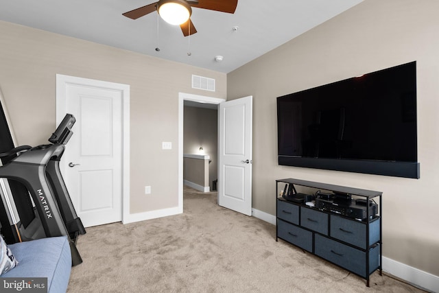 exercise area featuring visible vents, baseboards, light colored carpet, and ceiling fan