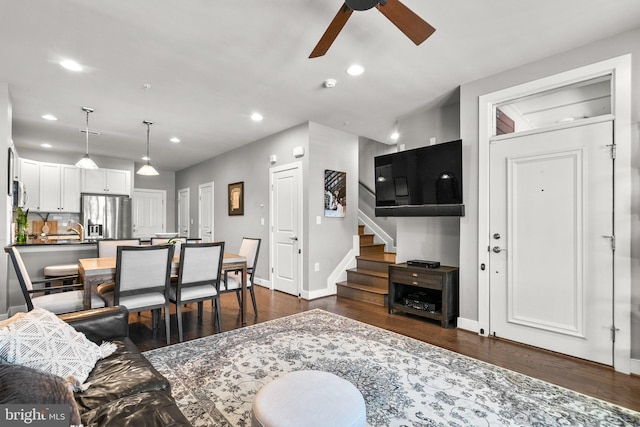 living room with baseboards, stairs, recessed lighting, a ceiling fan, and dark wood-style flooring