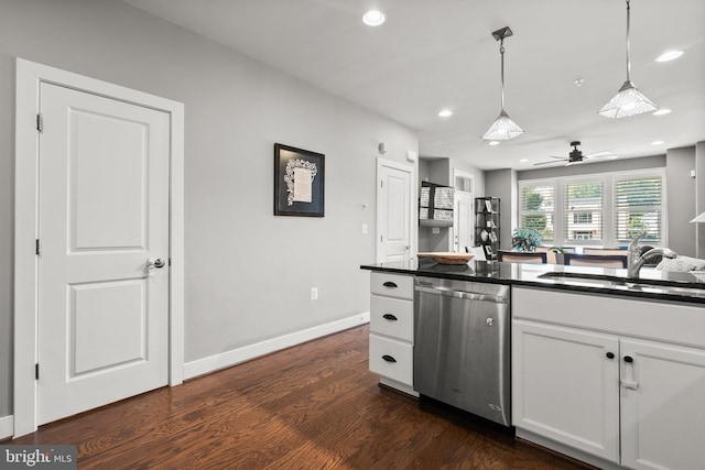 kitchen with dark countertops, dark wood finished floors, dishwasher, pendant lighting, and a sink