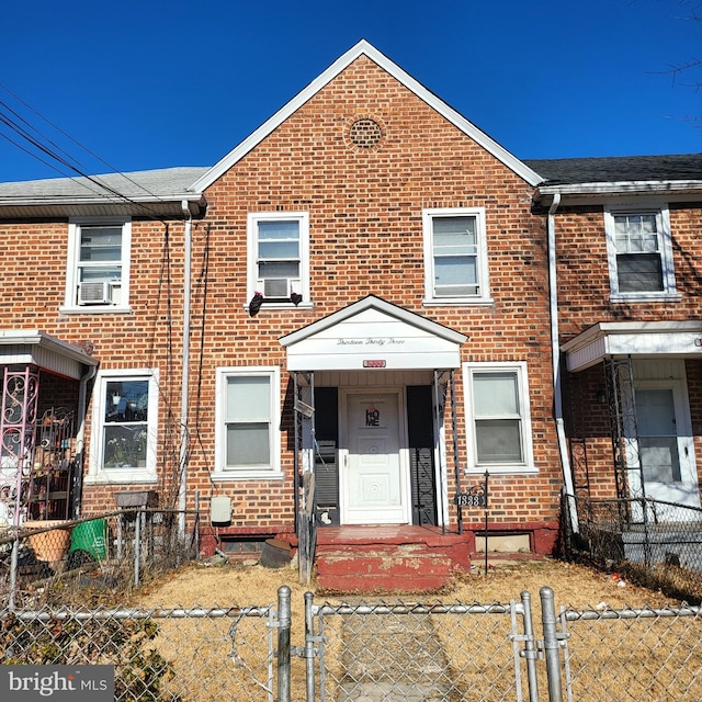 view of property featuring a fenced front yard, cooling unit, a gate, and brick siding