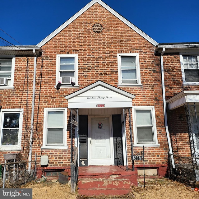 townhome / multi-family property featuring brick siding, cooling unit, and fence