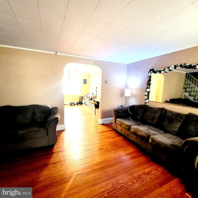 living room with arched walkways and wood finished floors