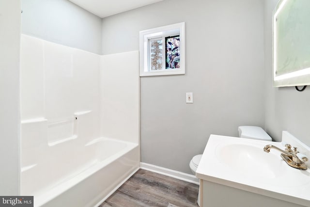 full bathroom with vanity, hardwood / wood-style flooring, shower / washtub combination, and toilet