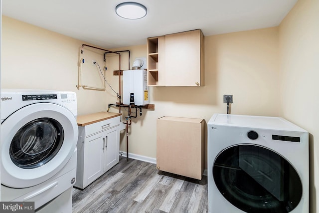 clothes washing area with water heater, wood-type flooring, independent washer and dryer, and cabinets