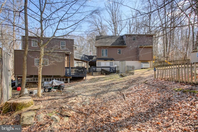 rear view of house with fence and a wooden deck