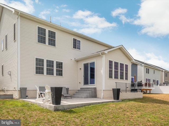 back of property featuring a lawn and a patio