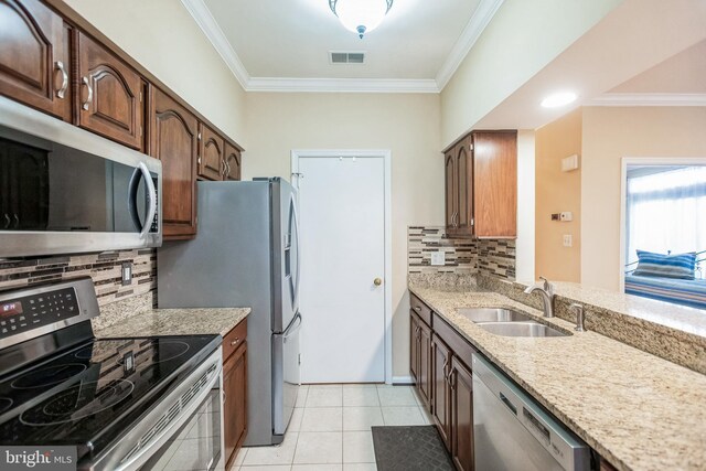 kitchen featuring visible vents, stainless steel appliances, a sink, and ornamental molding