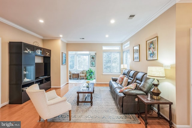 living area featuring ornamental molding and light wood-style flooring