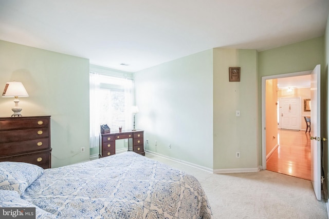 bedroom featuring light colored carpet and baseboards