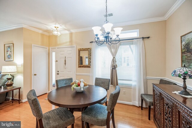 dining room with a chandelier, light wood-style flooring, visible vents, and crown molding