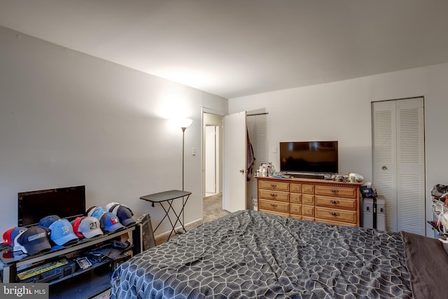 bedroom with multiple closets and carpet