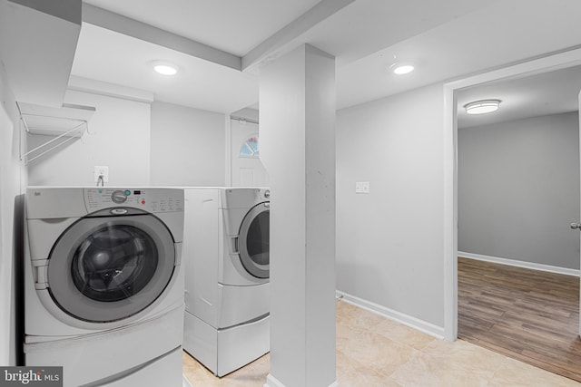 laundry area with laundry area, recessed lighting, washing machine and clothes dryer, and baseboards