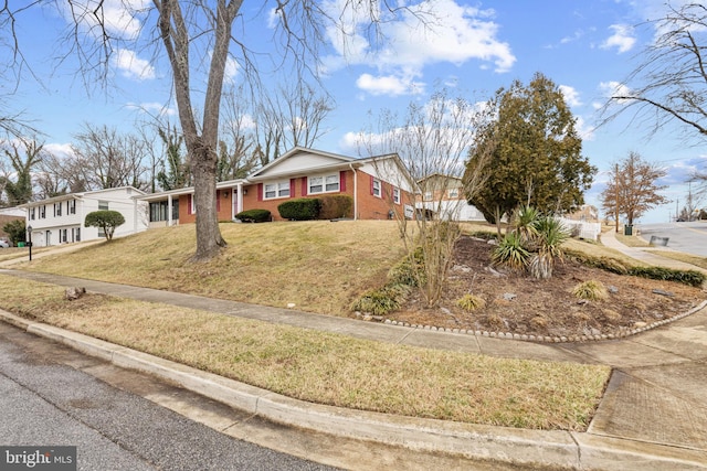 view of front of house with concrete driveway, brick siding, and a front lawn