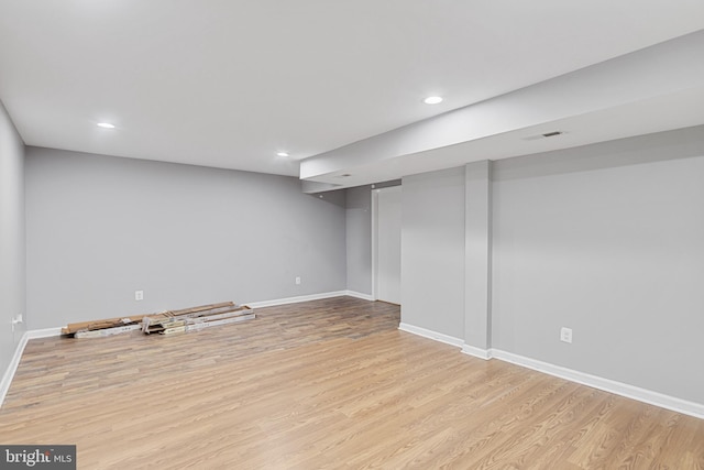 finished below grade area featuring recessed lighting, baseboards, and wood finished floors