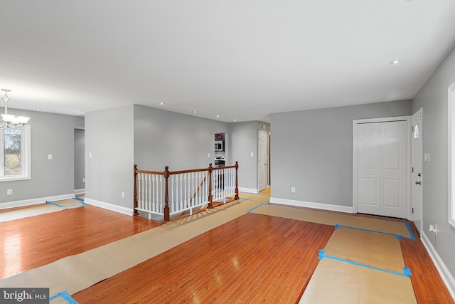 interior space with an inviting chandelier, baseboards, wood finished floors, and recessed lighting