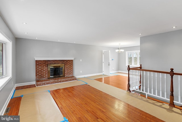 living room with baseboards, visible vents, wood finished floors, a fireplace, and recessed lighting