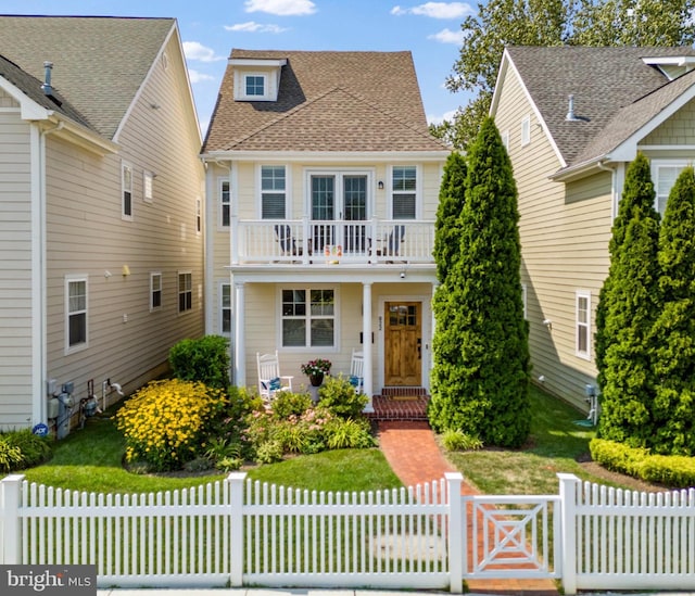 view of front facade with a balcony and a front yard