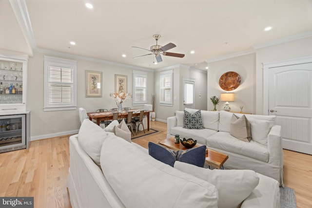 living room featuring crown molding, ceiling fan, and light wood-type flooring