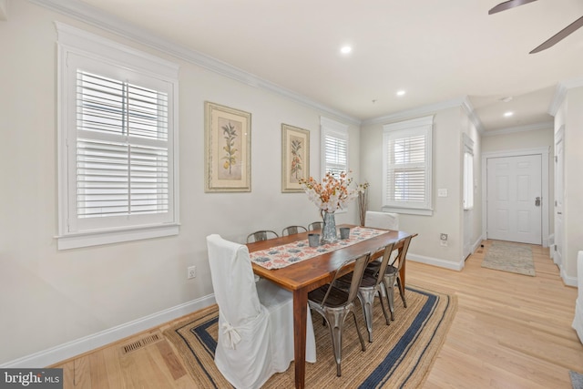 dining area with crown molding, ceiling fan, and light wood-type flooring