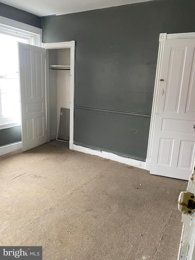 unfurnished bedroom featuring a closet and multiple windows