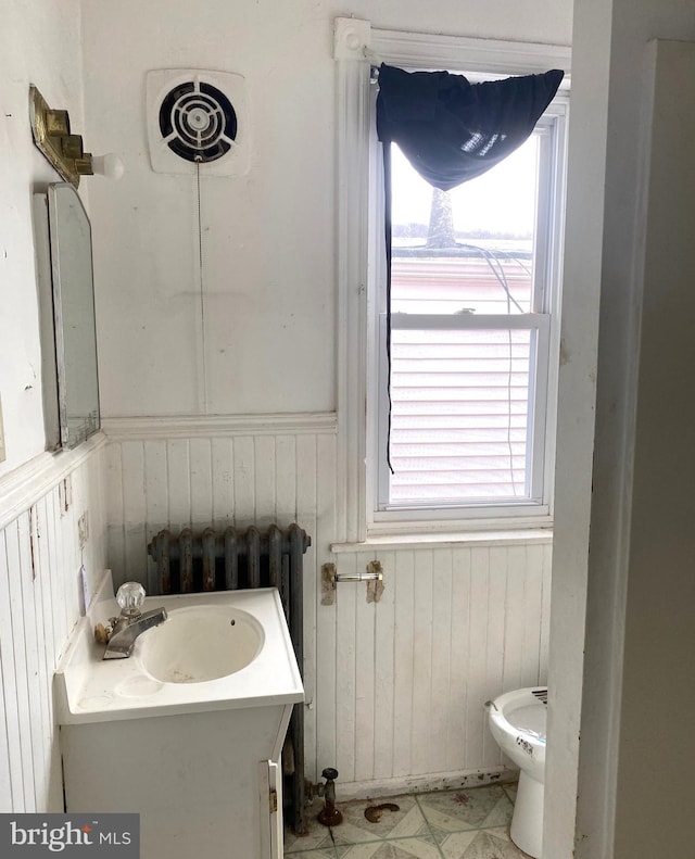 bathroom with vanity, radiator heating unit, and toilet