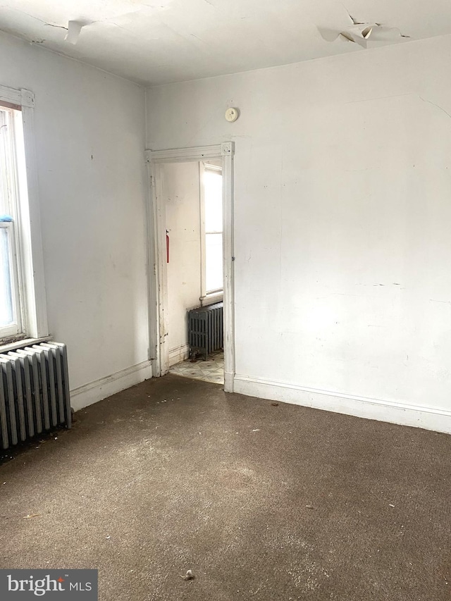 unfurnished room featuring radiator and a healthy amount of sunlight