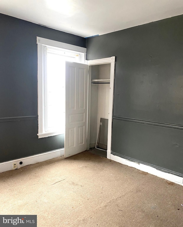 unfurnished bedroom with a closet and carpet