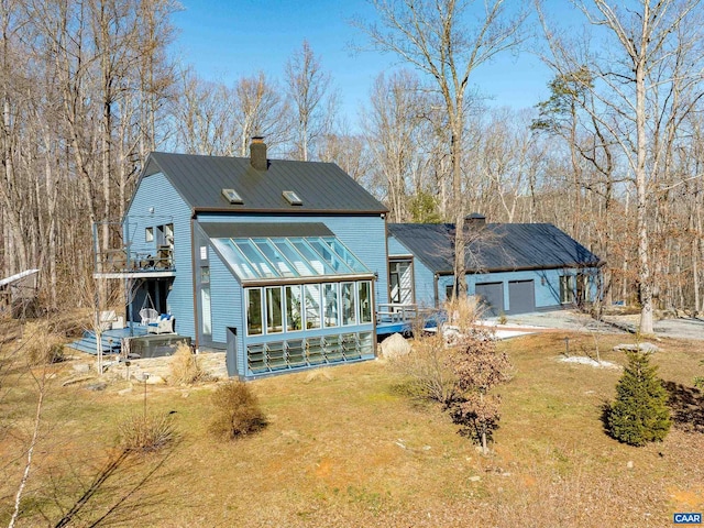 back of house with a yard, a sunroom, and a garage