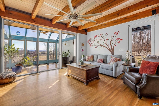 living room featuring beamed ceiling, ceiling fan, wood ceiling, and light hardwood / wood-style flooring