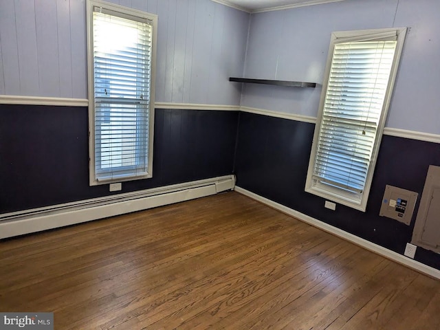 spare room with hardwood / wood-style flooring and a baseboard heating unit