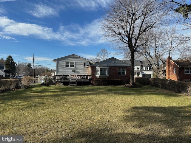 back of property featuring brick siding and a lawn