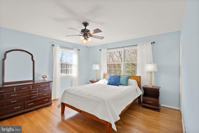 bedroom featuring light wood-type flooring, baseboards, and a ceiling fan