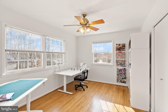 home office with baseboards, light wood-style flooring, and a ceiling fan