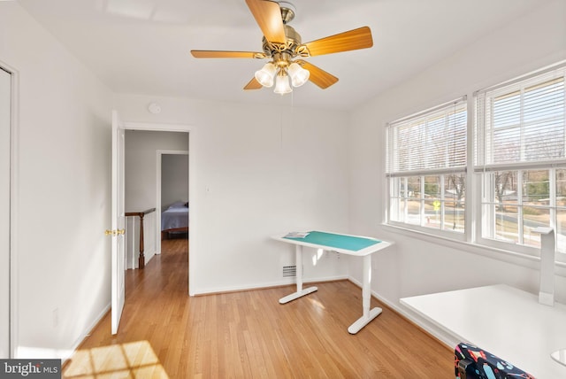 game room featuring light wood finished floors, ceiling fan, and baseboards