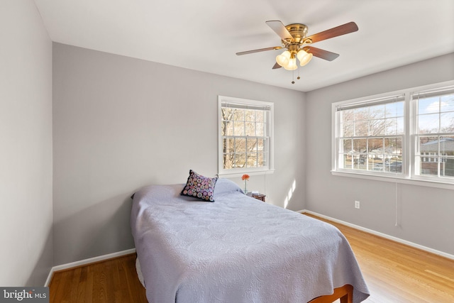 bedroom featuring ceiling fan, baseboards, and wood finished floors