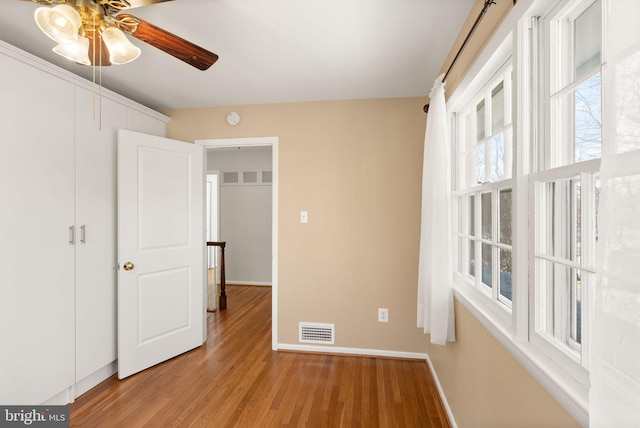 unfurnished bedroom featuring visible vents, light wood-style flooring, and baseboards