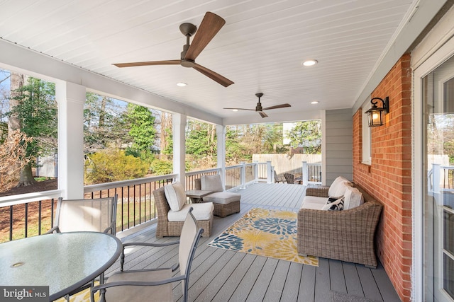 wooden deck with an outdoor living space, outdoor dining area, and ceiling fan