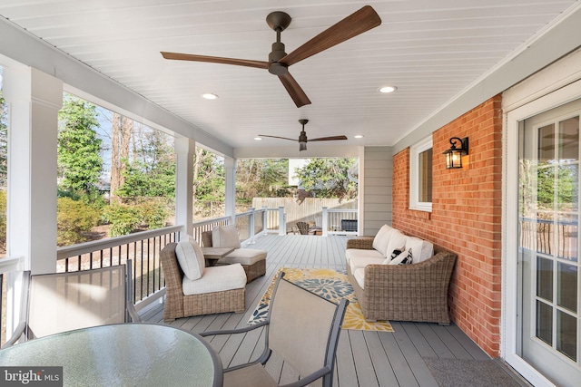 wooden deck featuring an outdoor living space and ceiling fan