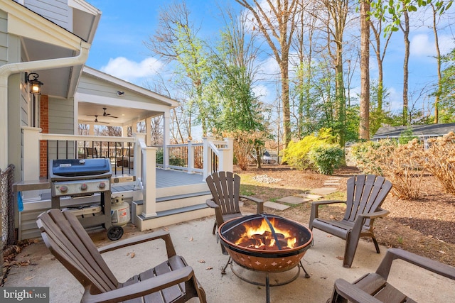 view of patio / terrace featuring a wooden deck, a fire pit, and a grill