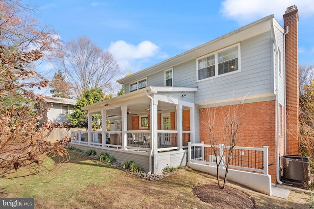 exterior space with brick siding, ceiling fan, central air condition unit, a porch, and a chimney